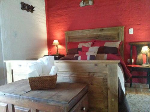 a bedroom with a bed with a red wall at Balcon de Antares in Uspallata