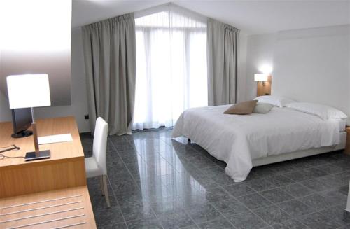 a hotel room with a bed and a desk and a desk at Vea Resort Hotel in Mercato San Severino
