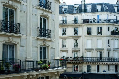 パリにあるHôtel Beaurepaireのバルコニーと窓のある建物の外観