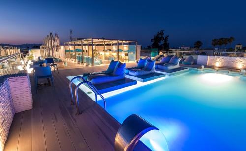 a pool on the roof of a building at night at Maritina Hotel in Kos Town