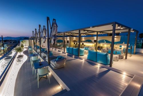 a rooftop deck with chairs and tables on a building at Maritina Hotel in Kos