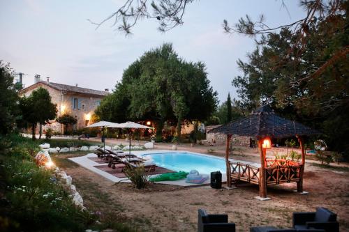 a swimming pool with a gazebo and a house at Mas d'Alphonse in Aigremont
