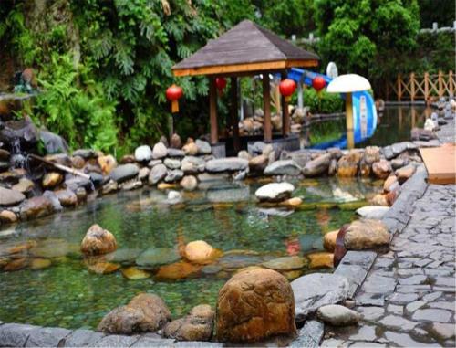 un laghetto con gazebo e un parco giochi di Longsheng Hot Spring Resort a Longsheng