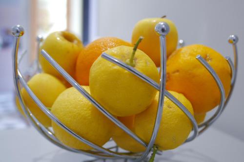 a bunch of oranges in a metal bowl at Hôtel Le Golfe Ecolabel EU in Porto Ota
