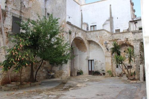 an old building with a tree in a courtyard at Home Holiday Salento Casa Agrosì Don Camillo in Presicce