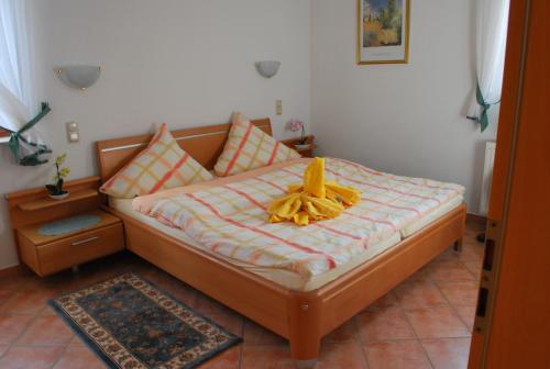 um quarto com uma cama com um laço amarelo em Christina em Tünsdorf