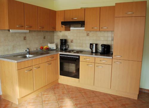 eine Küche mit Holzschränken und einem Waschbecken in der Unterkunft Christina in Tünsdorf