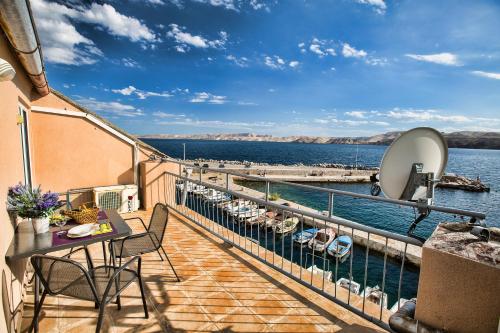 a balcony with a table and chairs and the water at Apartmani Cindrić in Karlobag