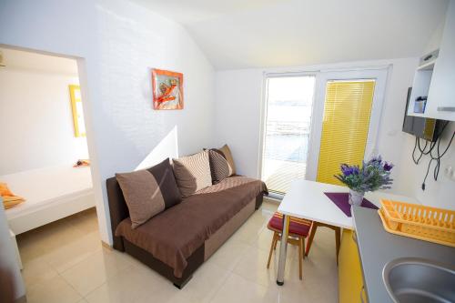 a living room with a couch and a table at Apartmani Cindrić in Karlobag