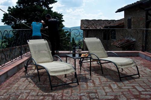 a couple of chairs and a table on a balcony at Agriturismo La Camporena in Greve in Chianti