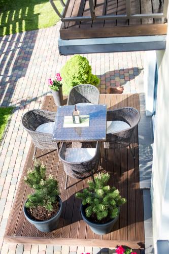 a table and chairs on a patio with potted plants at Rasos Vila in Palanga