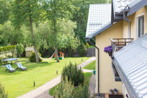 a backyard with a hammock and a playground at Rasos Vila in Palanga