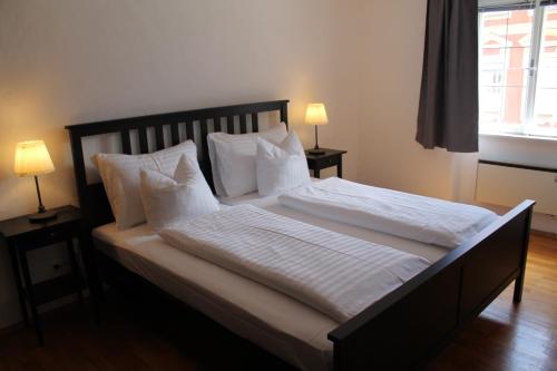 a bedroom with a large bed with white sheets and pillows at Appartement Triumphpforte in Innsbruck