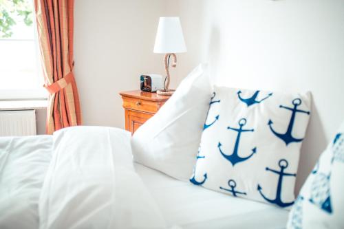 a bedroom with a bed with blue and white pillows at Strandhotel Strande in Strande