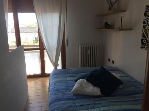 una camera da letto con un letto con lenzuola blu e una finestra di Luca's a Sesto Fiorentino