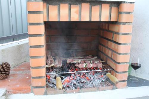 a brick fireplace filled with food and a glass of wine at Pro Touristic Casa Montejunto in Pereiro