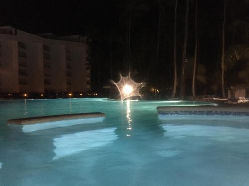 a pool of blue water at night with a light at Marbella Juan Dolio in Juan Dolio