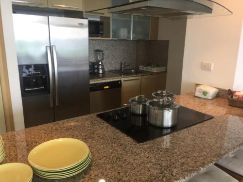 a kitchen with a stove and a refrigerator at Marbella Juan Dolio in Juan Dolio