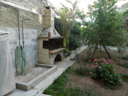 an outdoor brick oven in a yard with flowers at Sounio Palea Heaven in Palaiá Fókaia