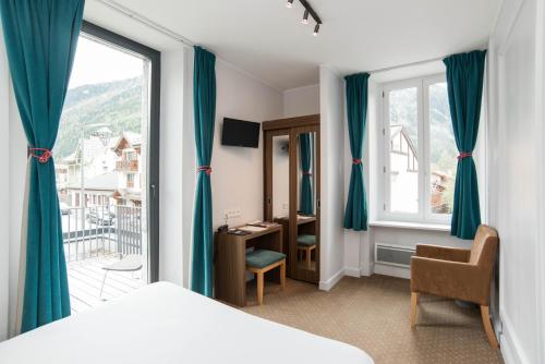 a bedroom with a bed and a large window at Hotel Les Lanchers in Chamonix-Mont-Blanc
