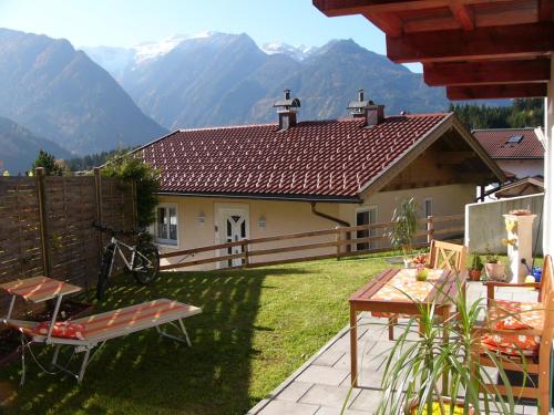 a backyard with a house with mountains in the background at Appartement Wildkogel in Neukirchen am Großvenediger