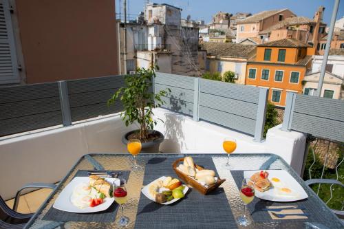 a table with two plates of food on a balcony at Casa Afrodite in Corfu Town