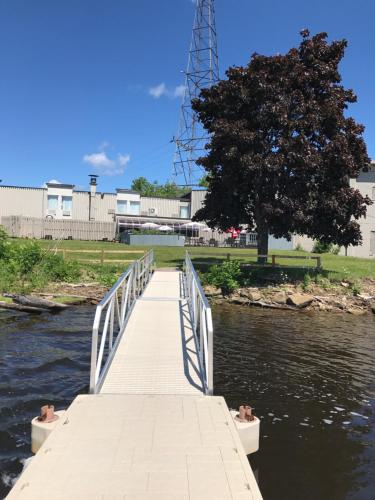 a wooden bridge over a river with a tree at Travelodge by Wyndham Miramichi New Brunswick in Miramichi
