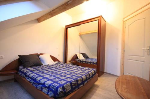 LandunvezにあるLa Maison Bleuの小さなベッドルーム(ベッド1台、鏡付)