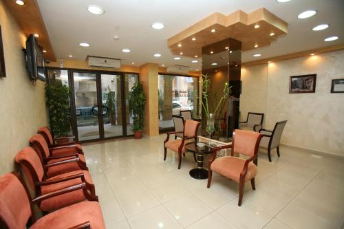 a waiting room with chairs and a table in a building at Cedar Hotel in Aqaba