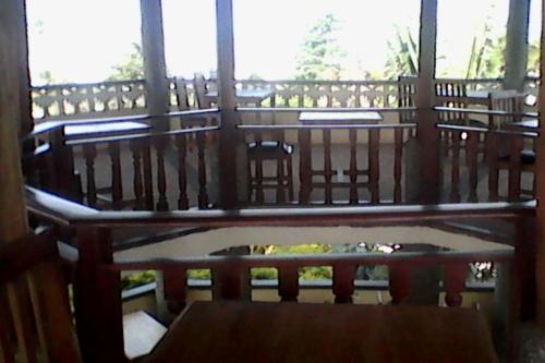 a room with a balcony with a table and chairs at Paradise Ocean Resort in Cape Coast