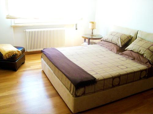 a large bed in a room with a wooden floor at Residenza Alice 2 - Toscana mare e monti in Camaiore