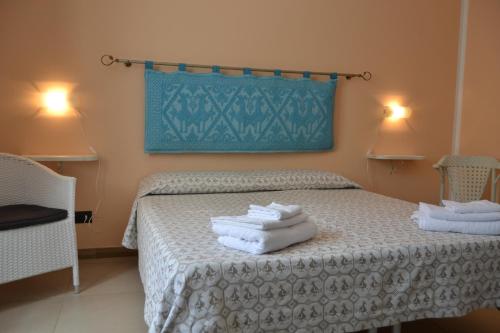 a bedroom with a bed with towels on it at B&B Fiori in Bonorva