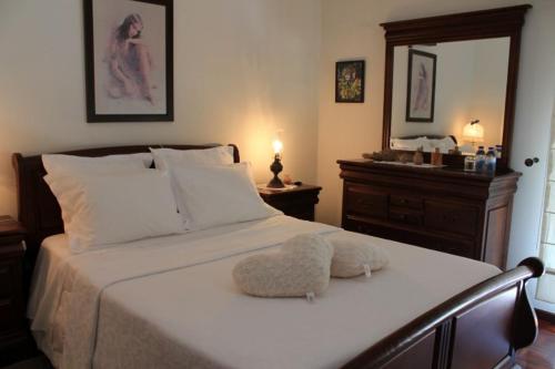 ein Schlafzimmer mit einem weißen Bett und einer Ottomane darauf in der Unterkunft Apartamento Avenida in Ponte de Lima