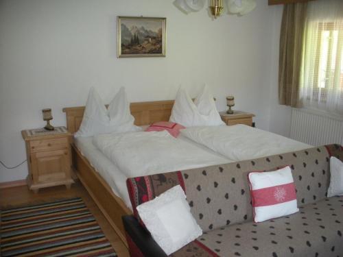 a bedroom with a large bed and a couch at Riedlhof in Kössen