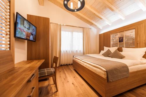 - une chambre avec un lit et une télévision dans l'établissement Chalet Oberstdorf, à Oberstdorf