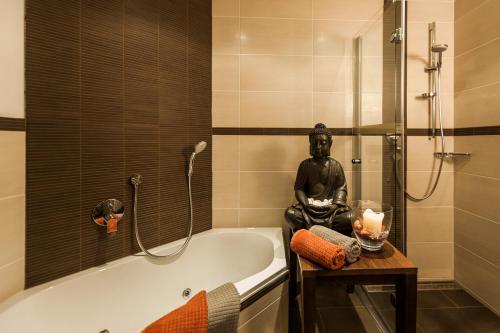 a statue of a man sitting on a bath tub in a bathroom at Chalet Oberstdorf in Oberstdorf