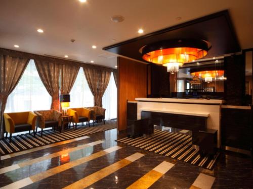 a lobby with a piano and a bar with chairs at APA Hotel Sendai Kotodai Koen in Sendai