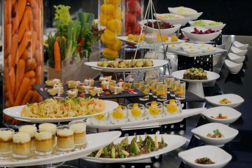 a buffet line with plates of food and drinks at Voco - Riyadh by IHG in Riyadh