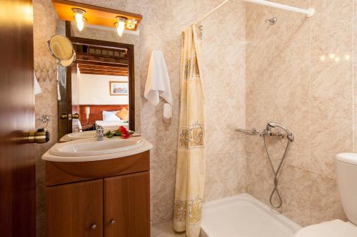 a bathroom with a sink and a toilet and a shower at Adelais Hotel in Tavronitis