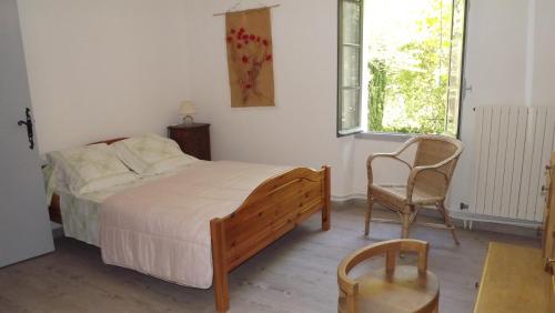 - une chambre avec un lit, une chaise et une fenêtre dans l'établissement La Bastide, à Cavaillon