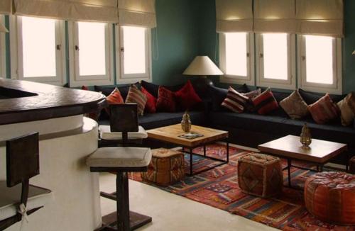 a living room with a black couch and red pillows at Auberge Dar Najmat in Mirleft