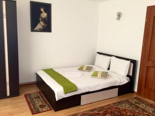 a bedroom with a bed with a green blanket on it at Casa Bella Turda in Turda