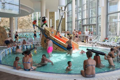 Eine Gruppe von Menschen im Schwimmbad eines Ferienresorts in der Unterkunft Central Apartman in Gyula