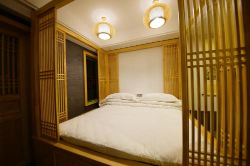a bedroom with a bed with white sheets at Pipa Hotel Datong in Datong