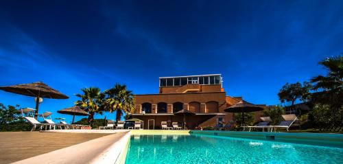 une piscine du complexe avec un bâtiment en arrière-plan dans l'établissement Villa Susanna Degli Ulivi - Resort & Spa, à Colonnella