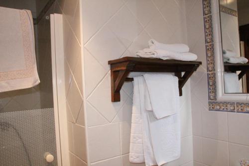 a bathroom with white towels on a shelf at Casa Rural Celtia in Aguilar del Río Alhama
