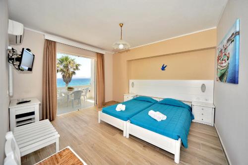 a bedroom with a bed and a view of the ocean at Byron Apartments in Tigaki