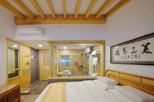 a bedroom with a large bed and a bathroom at Pipa Hotel Datong in Datong
