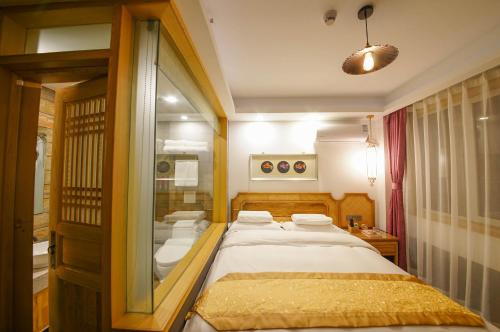 a bedroom with a bed and a glass door at Pipa Hotel Datong in Datong