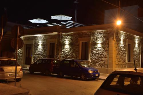 two cars parked in front of a building at night at La casa di Bice in Cassibile